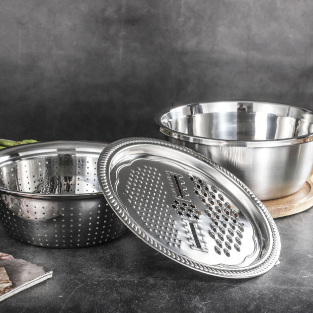 Stainless steel grater and bowl set on a dark surface with a blurred background