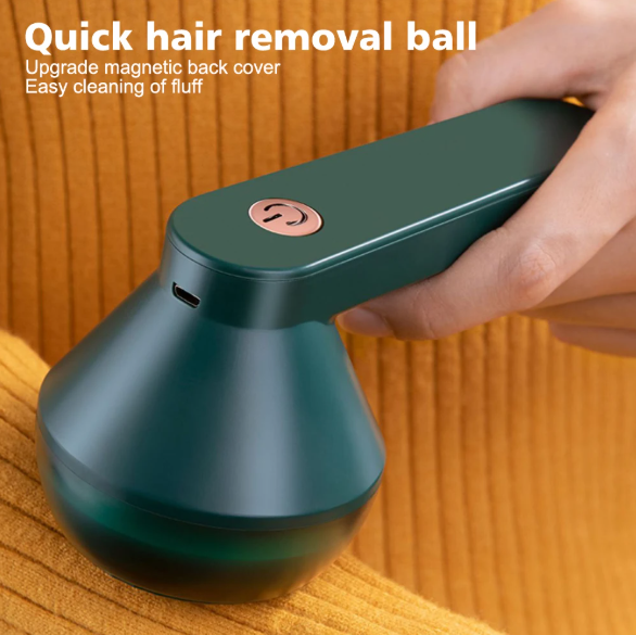 Green hair removal ball with hand holding it on a wooden surface