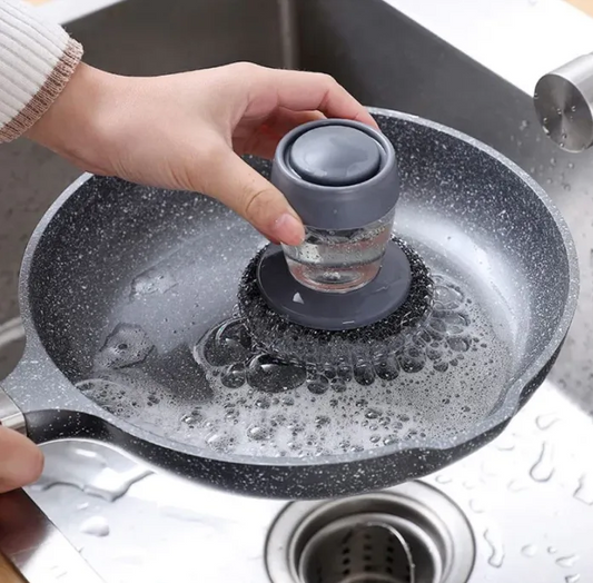 Person using a kitchen soap dispenser steel brush.